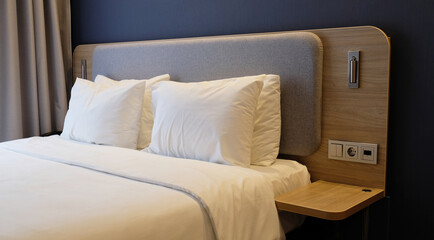 Close-up fragment of bedroom with empty bedside table, reading lamp and USB socket in modern...