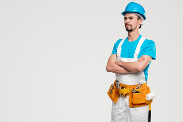 Confident builder in uniform with toolkit
