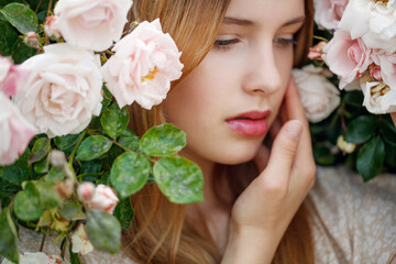 Obraz na płótnie Canvas Beautiful young woman smells a rose flower. High quality photo
