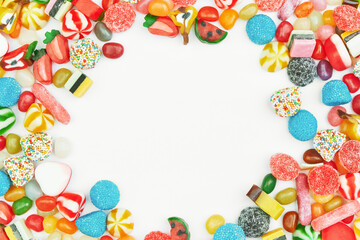 Multi-colored gummy candies on a white background. Free space in the center. Festive frame backdrop.