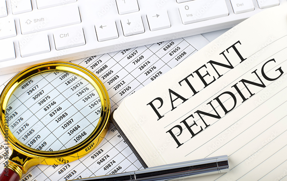 Poster patent pending text on notebook with chart, magnifier,keyboard and pen