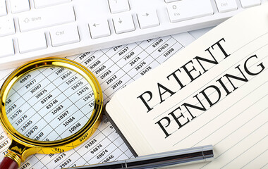 PATENT PENDING text on notebook with chart, magnifier,keyboard and pen