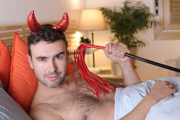 Spooky man in bed with red horns

