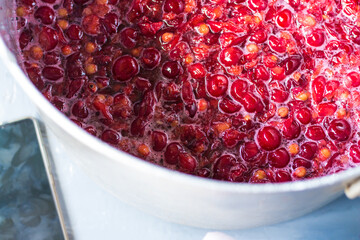 Red ripe cherries in a saucepan during the preparation of a cherry liqueur. Preservation, cherry jam, compote