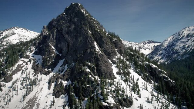 Mountain Peak Drone Parallax with Jagged Rocks in Spring Snow