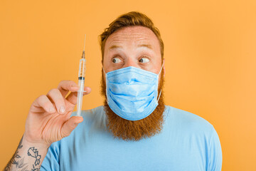 Amazed man with beard, tattoo and mask for covid-19 is ready for the virus vaccine