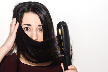 Close-up of a beautiful young woman with long black shiny hair looking surprised while using a flat...