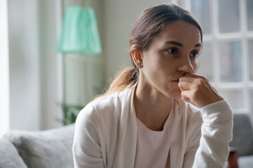 Close up of sad millennial Caucasian female look in distance think ponder of family divorce...