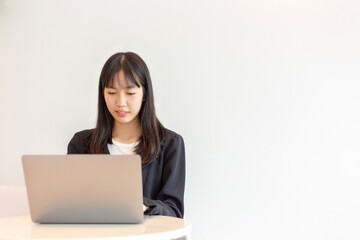 Asian woman using laptop on white background.