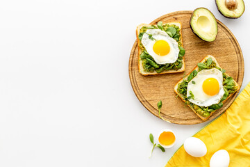 Breakfast with toasts of fried eggs and avocado saurce. Top view