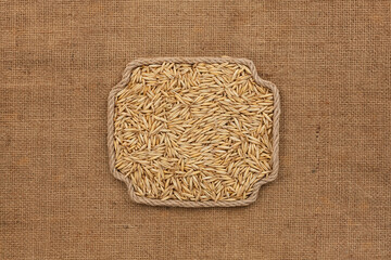 Frame made of rope with a whole, ripe oat grain. With space for design, text place.