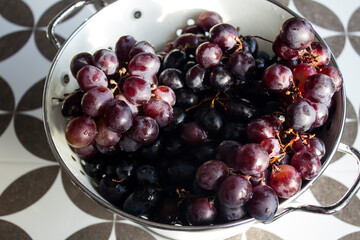 Grapes in a vase. Close up photo of fresh seasonal fruits. Eating fresh concept. Beautiful grapes on a table. Summer berries texture. 