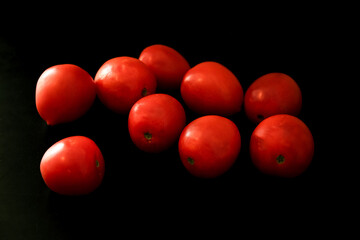 Fresh red cherry tomatoes with the inscription over black background