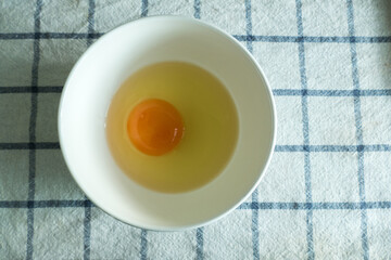 Fresh raw egg in white bowl for homemade food concept