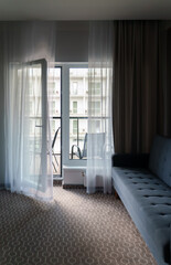 Room interior with sofa and open balcony.