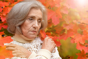 Portrait of sad senior woman in autumn park