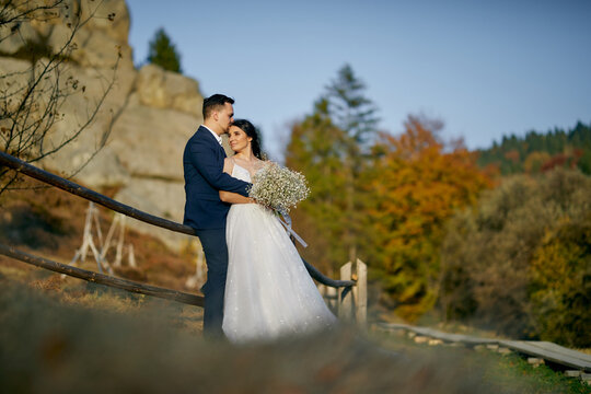 A wedding couple is embracing with beautiful background of mountains. Outdoor.