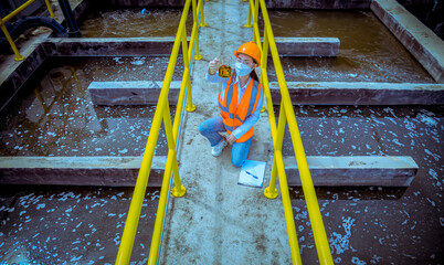 Worker under checking the waste water treatment pond industry large to control water support...