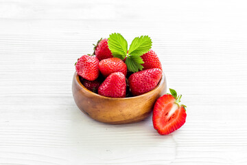Strawberry in wooden bowl with leaves, close up