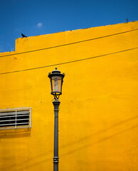 Puerto Rico street lamp post against bright yellow wall and blue sky 