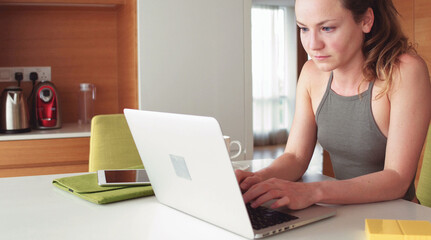 Beautiful blond woman with a laptop computer at home
