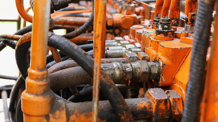 Old hydraulic valves and hoses. The pipeline system of the hydraulic valve of the mobile crane....