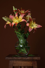 Vase with flowers lilies on a brown background