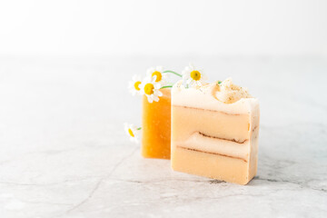 Homemade herbal Soap with chamomile Flowers on white marble background. Zero waste, natural organic bathroom cosmetics. Plastic free life. Ecological skin care, body treatment concept