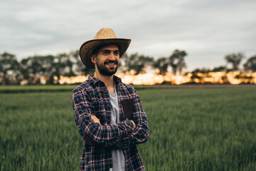 farmer posing arms crossed on corn field
