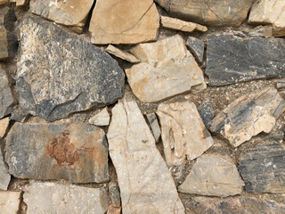 Old ancient wall with different stones as abstract background
