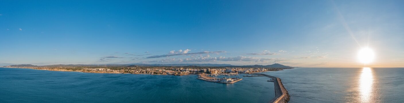 Drone panorama of the Spanish town of Vinaros with the large breakwater at the entrance to the port during sunrise
