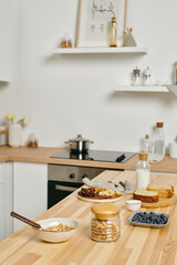 Wooden kitchen table with fresh ingredients for cooking tasty breakfast