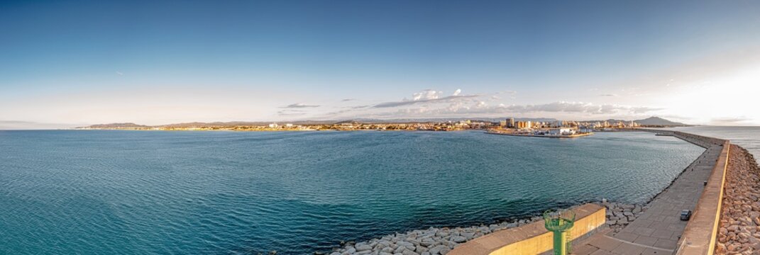 Drone panorama of the Spanish town of Vinaros with the large breakwater at the entrance to the port during sunrise
