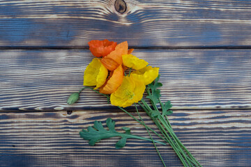 Bouquet of yellow and orange poppies on a wooden background
