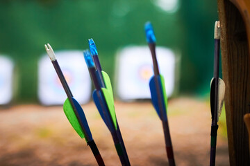 Closeup of plastic arrow nocks and fletching in a quiver with targets blurred in the background