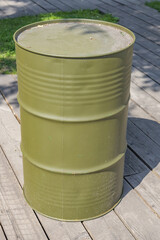 Naklejka premium A barrel for storing oil in khaki color stands on wooden boards