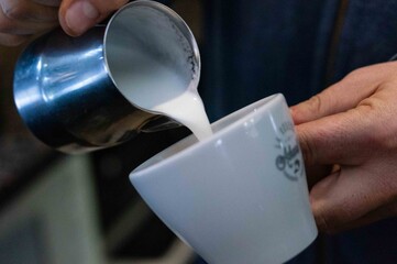 taza de café con espuma de leche recién hecho en máquina cafetera