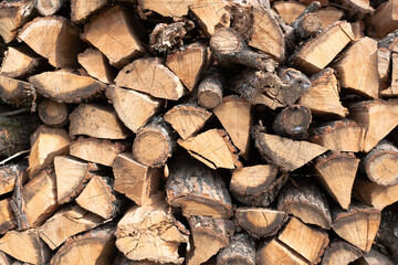 Stacked firewood background. Firewood pattern. Wood saving wall. Stock of wood for kindling a fireplace for the winter. Natural materials background.