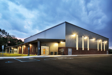 Exterior of large warehouse gym building at night - obrazy, fototapety, plakaty