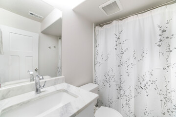 Interior of a bathroom with white sink marble top and mirror