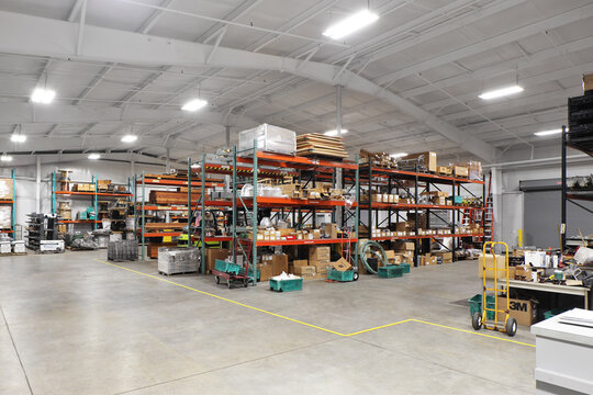 Shelves of boxes and merchandise in industrial warehouse packing distribution facility