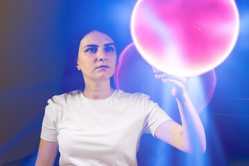 A concentrated woman looks at the pink burning ball. Quantum theory of man, consciousness and...