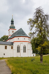 Fototapeta na wymiar Krasne Brezno, Bohemia, Czech Republic, 26 June 2021: Saxony style renaissance church of St. Florian with white tower and gothic windows, National cultural monument in summer day