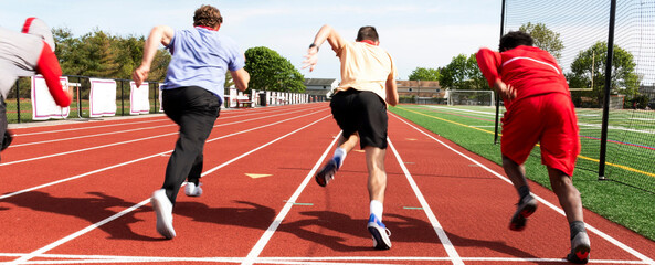 Four runners starting a sprint race at practice from behind