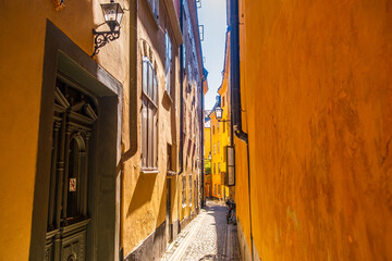 Colourful historic buildings and houses in Gamla Stan. Romantic medieval city centre alleys. Popular tourist destination in Scandinavia on a sunny day.