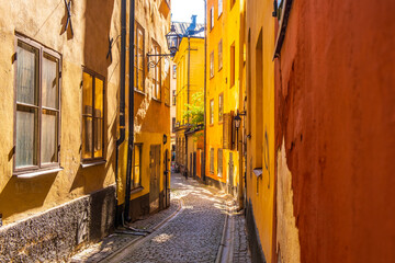 Colourful historic buildings and houses in Gamla Stan. Romantic medieval city centre alleys. Popular tourist destination in Scandinavia on a sunny day.