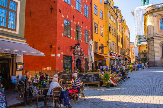 Stockholm Sweden - July 1 2021: Colourful historic buildings and houses in Gamla Stan, Main S. Romantic medieval city centre alleys. Popular tourist destination in Scandinavia on a sunny day. - Powered by Adobe