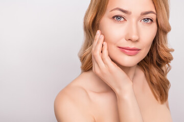Cropped photo portrait woman naked shoulders hydrating anti age cream on cheek isolated white color...