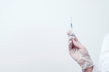 Doctor holding syringe with vaccine. Vaccination and immunization concept. Copy space.