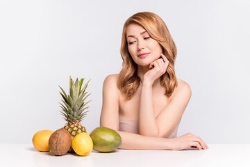 Portrait of attractive curious woman looking at citrus fruits choosing juice weight loss menu dietary isolated over grey pastel color background